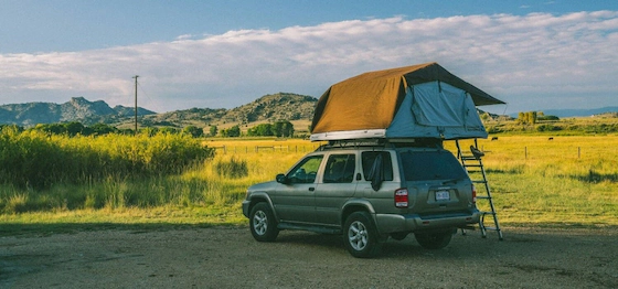 Автомобиль с палаткой на крыше на стоянке во время путешествия